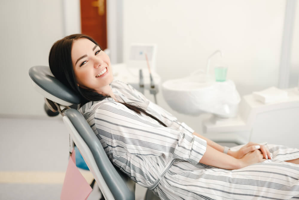 Smiling and satisfied patient in a dental office after treatment